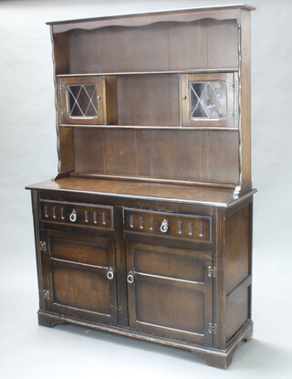 A light oak dresser, the raised back with moulded cornice fitted a shelf above recess flanked by cupboards enclosed by lead glazed panelled doors above 2 drawers and a double cupboard enclosed by panelled doors 175cm h x 121cm w x 40cm d 