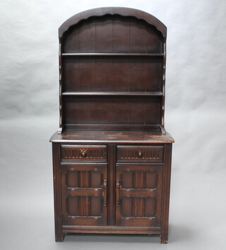 A dark elm dresser with arched back fitted 2 shelves, the base 2 drawers above double cupboard 175cm h x 91cm w x 42cm d (contact marks and water marks to the top) 