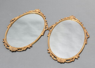 A pair of oval plate wall mirrors contained in decorative gilt frames 67cm x 39cm  
