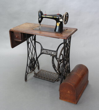 A Singer treadle operated sewing machine no. Y2470420 74cm h x 70cm w x 41cm d (veneers lifting and missing to the top)