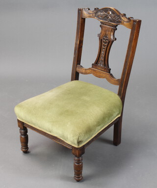 An Edwardian carved mahogany salon chair with vase shaped slap back and overstuffed seat, on turned supports