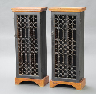 A pair of Eastern hardwood and black painted CD racks enclosed by grilled panelled doors 86cm h x 34cm w x 21cm d 