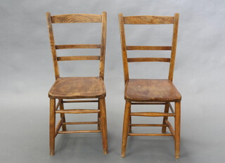 A pair of beech and elm ladder back chairs with solid seats raised on turned supports, H framed stretcher 84cm h x 34cm w x 34cm d (seat 25cm x 27cm)