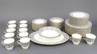 A Mikasa Oxford pattern tea and dinner service with bands of scrolling leaves comprising tea cups, saucers, side plates, medium plates, dinner plates, serving plate