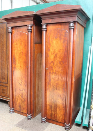 A pair of 19th Century mahogany sentry box wardrobes with moulded cornice enclosed by panelled door with Roman columns to the sides 192cm h x 72cm w x 71cm d (veneers missing in places)