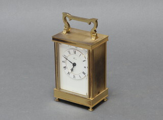A modern brass carriage timepiece raised on turned feet 16cm to handle 
