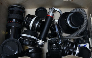 A Tamron SLR lens together with minor camera lenses and accessories