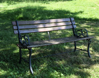 A well weathered metal and wooden slatted garden bench 69cm h x 124cm w x 38cm d (seat 101cm w x 36cm d)
