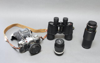 A Canon camera with accessories cased, a pair of 10x5 Solus binoculars cased and 1 other camera  