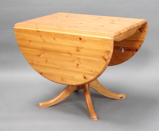 An oval pine pedestal drop flap dining table 73cm h x 92cm w x 64cm d 
