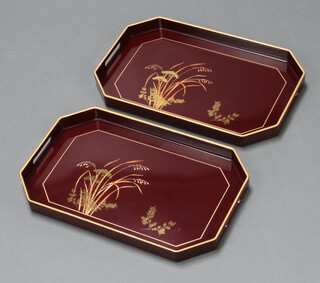 Two Japanese red lacquered interfitting twin handled tea trays with floral decoration 4cm h x 48cm w x 31cm d  