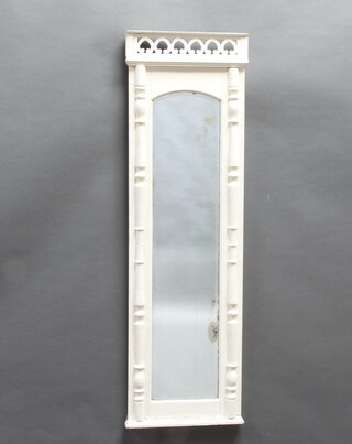 An arched rectangular bevelled plate wall mirror contained in a white painted frame with columns to the sides 129cm h x 39cm w x 4cm d (silvering to the mirror showing signs of deterioration) 