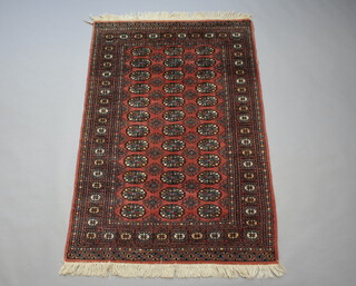 A pink and white ground Bokhara rug with 36 octagons to the centre 180cm x 123cm 