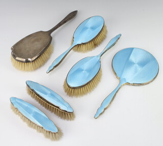 An Art Deco silver blue guilloche enamelled dressing table set comprising hand mirror, 2 hair brushes and 2 clothes brushes Birmingham 1932 together with a silver backed hair brush London 1943 