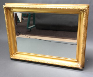 A 19th Century rectangular/cushion shaped gilt mirror frame containing a later bevelled plate mirror 124cm h x 92cm w x 13cm d 