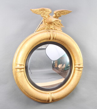 A Regency convex plate wall mirror contained in a circular gilt frame surmounted by a figure of an eagle 89cm h x 79cm diam. 
