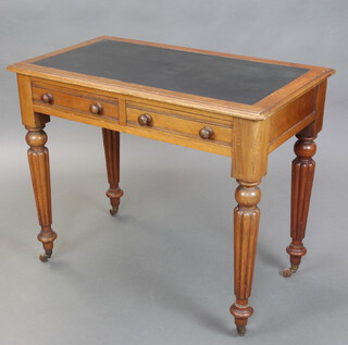 A Victorian mahogany writing table with inset writing surface, fitted 2 drawers with tore handles, raised on turned and reeded supports, ceramic casters, 75cm h x 92cm w x 52cm d 