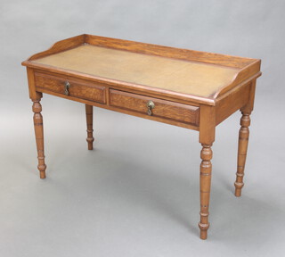 An Edwardian Art Nouveau mahogany writing table fitted a 3/4 gallery with inset writing surface fitted 2 drawers, raised on turned supports 72cm h x 104cm w x 49cm d 