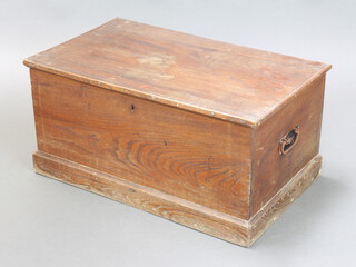 A 19th Century elm trunk with hinged lid and iron drop handles, the interior fitted a candle box, raised on a platform base 39cm h x 79cm w x 46cm d 