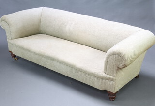 A Victorian Chesterfield upholstered in cream patterned material, raised on turned oak supports 59cm h x 194cm w x 72cm d (seat 137cm x 47cm), raised on later brass casters