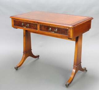 A Victorian style walnut writing table with inset brown writing surface, fitted 2 long drawers, raised on standard end supports, brass caps and casters 76cm h x 90cm w x 58cm d 