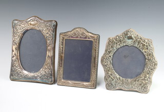 A Victorian style silver repousse photograph frame decorated with cherubs London 1984, 18cm and 2 others