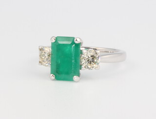 An 18ct white gold emerald and diamond ring the baguette cut emerald approx. 1.92ct, the 2 brilliant cut diamonds 0.81ct, 4.2 grams, size M 1/2, with WGI certificate 