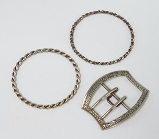 Two silver bangles together with a silver buckle, 68 grams