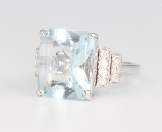 An 18ct white gold Art Deco style aquamarine ring with centre square stone 7.06ct flanked by 14 brilliant cut diamonds 0.32ct, 6.8 grams, size N