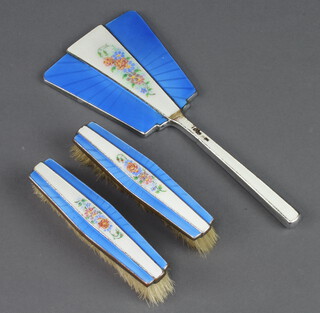 An Art Deco chromium plated and enamelled dressing table set comprising hand mirror and 2 clothes brushes decorated with flowers 