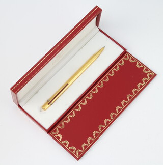 A Must De Cartier gold plated propelling pencil no.109934, cased and with original guarantee and booklet 