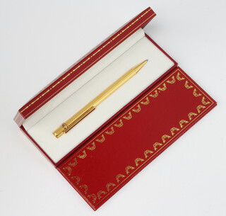 A Must De Cartier gold plated ballpoint pen with original guarantee and booklet, boxed