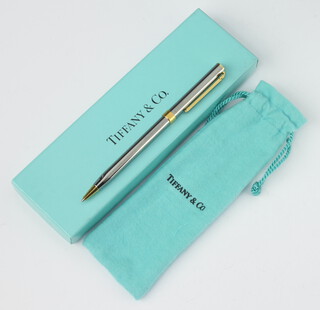 A Tiffany & Co polished steel and brass ballpoint pen with pouch and box 