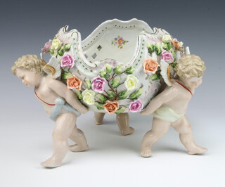 A 20th Century German centrepiece, the pierced and floral applied bowls supported by 3 cherubs 23cm h
