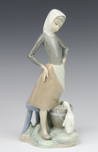 A Lladro figure of a young lady standing beside a pail with a goose 22cm 