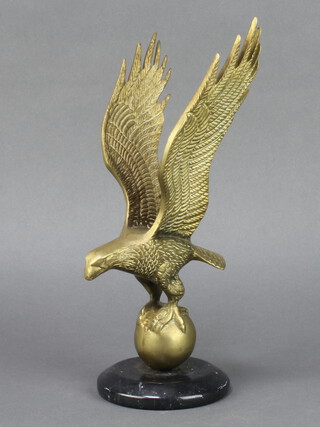 A brass figure of an albatross upon a globe, raised on a black marble socle base 27cm x 10cm 