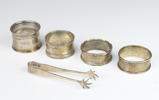 A silver napkin ring Birmingham 1918, 3 others, a pair of tongs, 110 grams 