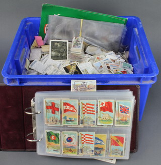 A blue crate of mixed cigarette cards