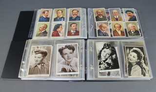 An album of black and white postcards of actresses and other postcards together with a red loose leaf album of trade cards, seals etc 