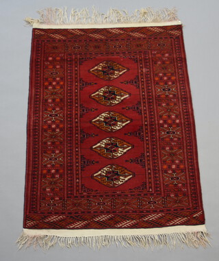 A red and blue ground Bokhara rug with 5 diamonds to the centre within a multi row border 118cm x 86cm 