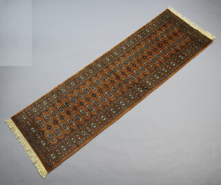 A tanned ground Bokhara runner with 48 octagons to the centre 256cm x 81cm 