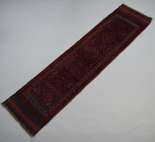 A red and blue ground Meshwani runner with 5 stylised diamonds to the centre within a multi row border 247cm x 62cm 