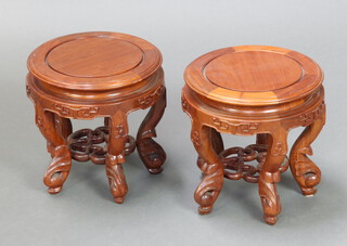 A very near pair of 20th Century circular Chinese carved hardwood jardiniere stands, raised on shaped supports with pierced undertier 27cm h x 26cm diam. 