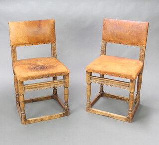 A pair of 17th Century style oak dining chairs, the seats and backs upholstered in leather and raised on turned and block supports 85cm h x 44cm w x 40cm d (seat 33cm x 26cm) 