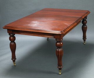 A Victorian style mahogany extending dining table with 2 extra leaves, raised on turned and reeded supports with brass caps and casters 79cm h x 111cm w x 135cm l x 216cm when extended 