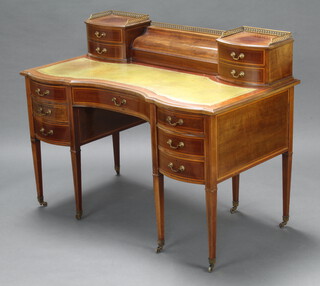 An Edwardian inlaid mahogany writing table, the super structure fitted a stationery box enclosed by serpentine shaped lid flanked by 4 long drawers with green inset writing surface above 1 long and 6 short drawers, raised on square tapered supports, brass caps and casters 95cm h x 122cm w x 65cm d 