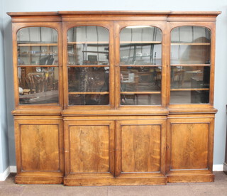 A Victorian rosewood triple breakfront bookcase, the upper section with moulded cornice fitted shelves enclosed by arched glazed panelled doors, the base fitted cupboards enclosed by panelled doors 210cm h x 250cm w x 43cm d  