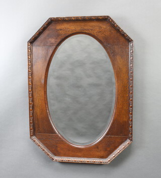 A 1930's oval bevelled plate wall mirror contained in a carved oak shaped frame 77cm h x 56cm w 