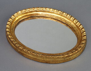 An oval plate wall mirror contained in a decorative gilt frame 21cm x 27cm 