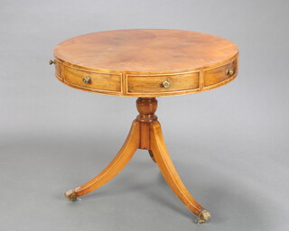A Georgian style yew quarter veneered and crossbanded drum table fitted 4 frieze drawers, raised on a turned column and tripod base with paw caps and casters 71cm h x 77cm diam. 